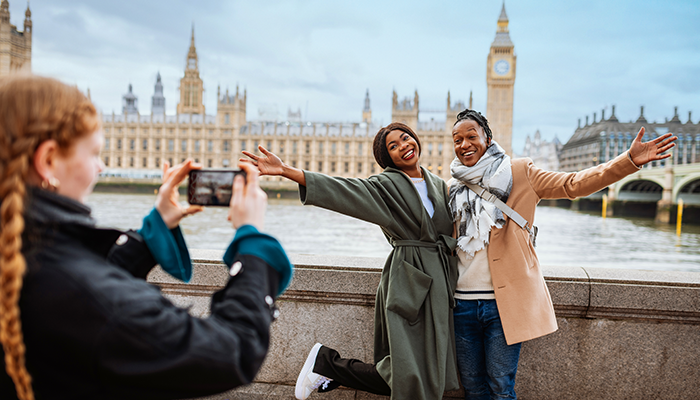 Two friends smiling in London in front of the Big Ben