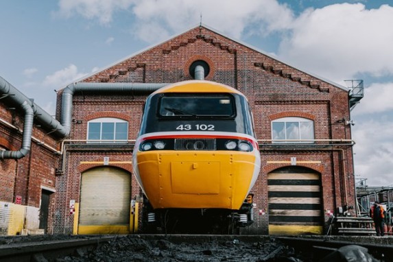 Image showing HST 43102 in original livery, freshly painted. This view shows the front of the train, with the depot building behind, the driver's cab is in the centre of the image.